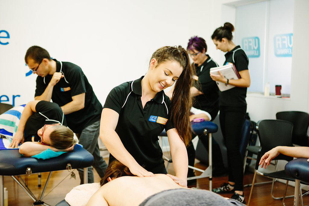 VFA Learning student practicing as a personal trainer and remedial massage therapist in a classroom setting.